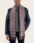 Model wearing an Oliverman burgundy, navy and beige checked lambswool scarf against a cream background